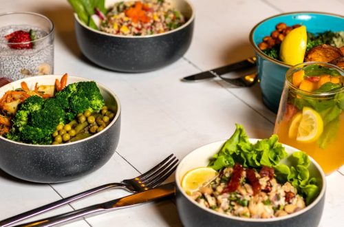 A vibrant assortment of healthy bowls and drinks showcasing fresh ingredients like broccoli and citrus.